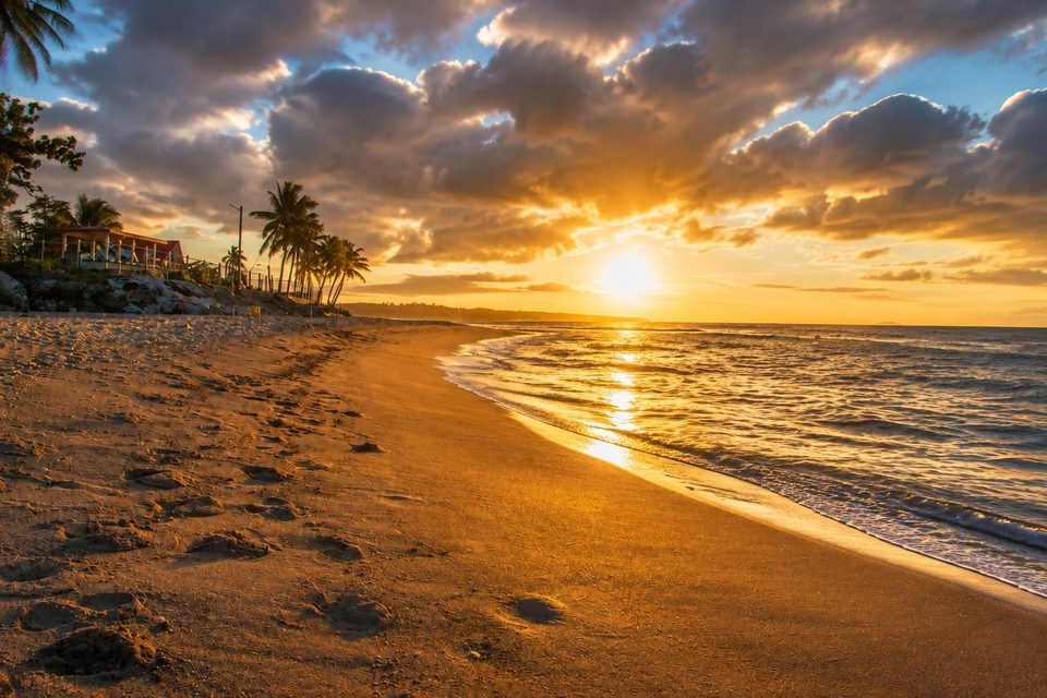 Sunset on the shoreline, the sun low over the water