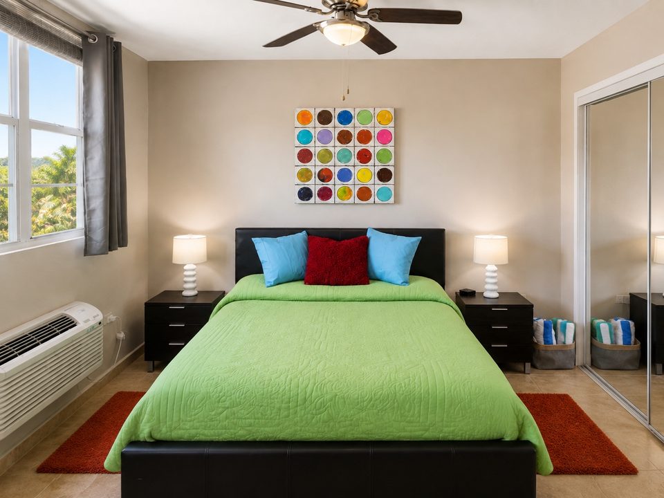 Bedroom two: the bed under a ceiling fan, air conditioning and a wide window