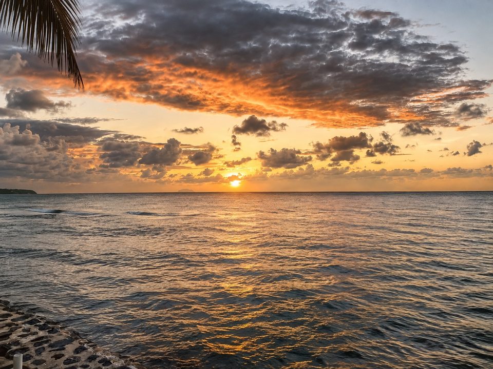 An orange and grey sunset sky over the ocean