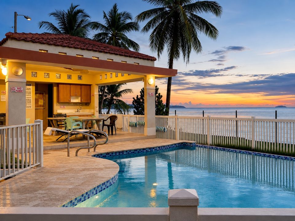 The shared pool lit at dusk, the gazebo and the ocean behind the fence