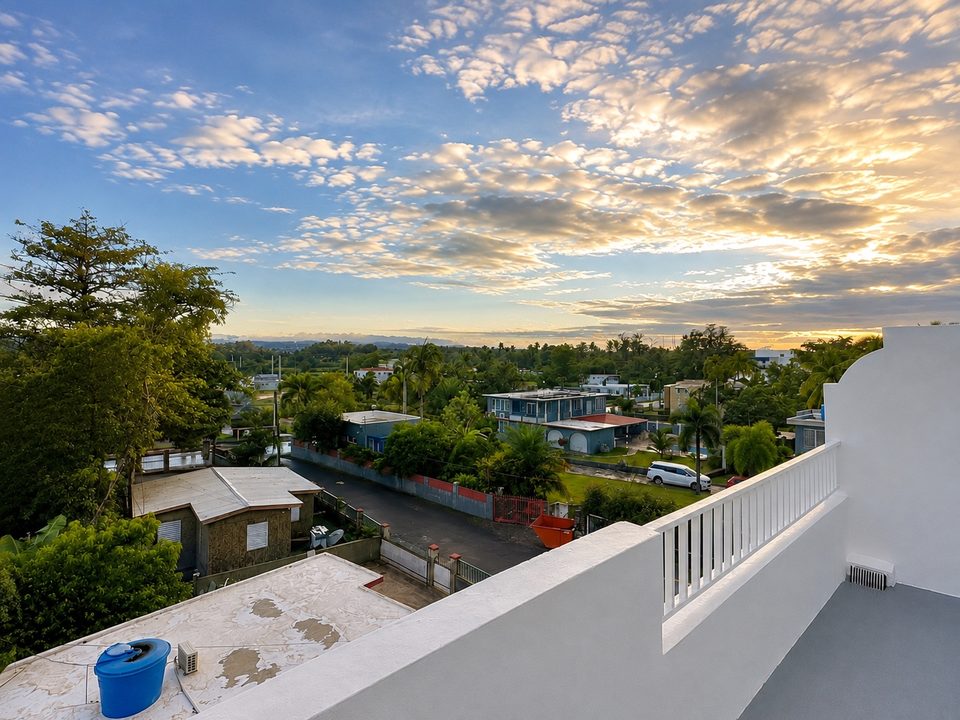 Sunset from the rooftop, looking inland over palms and rooftops